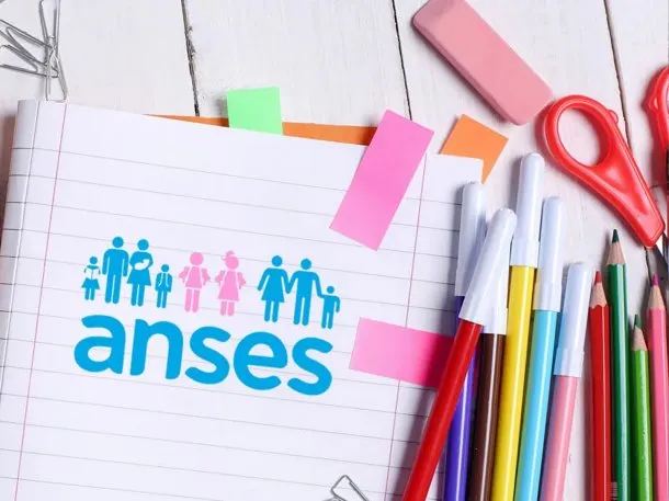 Imagen de una familia sonriendo con un chequeo de ANSES en la mano