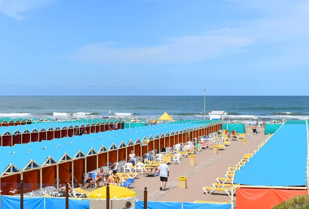 Turista pagando por sombrilla en Mar del Plata