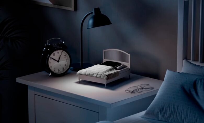Imagen de la mini-cama para móviles de IKEA, con un teléfono inteligente colocado en su superficie