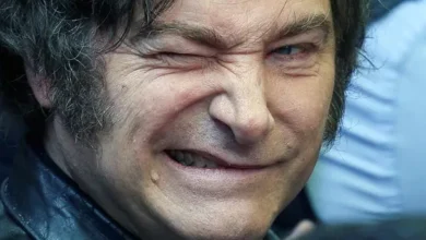 Javier Milei sonriendo con el escudo de Estudiantes de La Plata