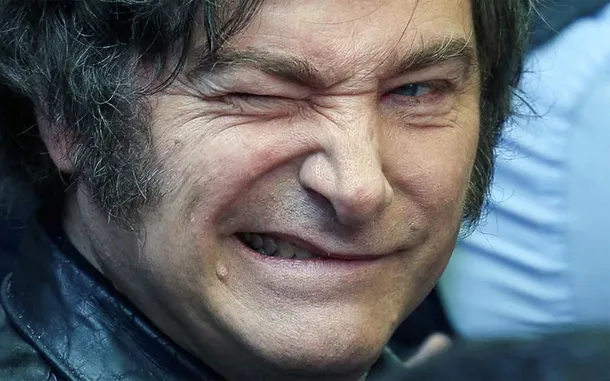 Javier Milei sonriendo con el escudo de Estudiantes de La Plata