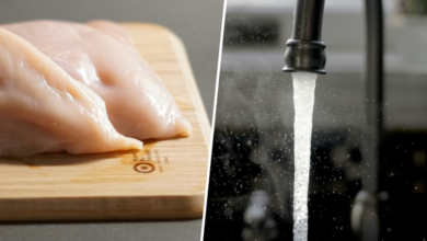 Imagen de un pollo crudo en un fregadero con agua corriendo