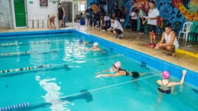 Grupo de personas en un natatorio recibiendo instrucción para convertirse en guardavidas