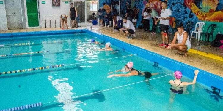 Grupo de personas en un natatorio recibiendo instrucción para convertirse en guardavidas