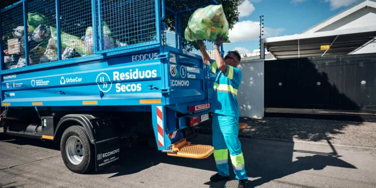 Persona separando residuos en dos contenedores