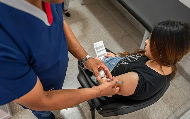 Mujer embarazada recibiendo una vacuna en un centro de salud