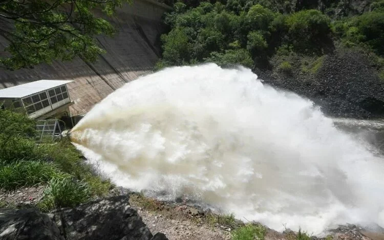 Imagen del dique San Roque con la válvula abierta y agua cayendo