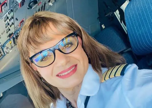 Traniela Campolieto, piloto trans, sonríe en una imagen con un fondo de aviones