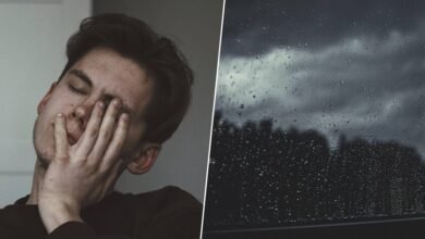 Persona sentada en un sillón, mirando la lluvia por la ventana