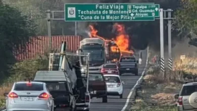 Imagen de una calle desierta en México con un vehículo incendiado
