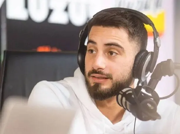 Nico Occhiato sonriendo y mostrando su salario en dólares