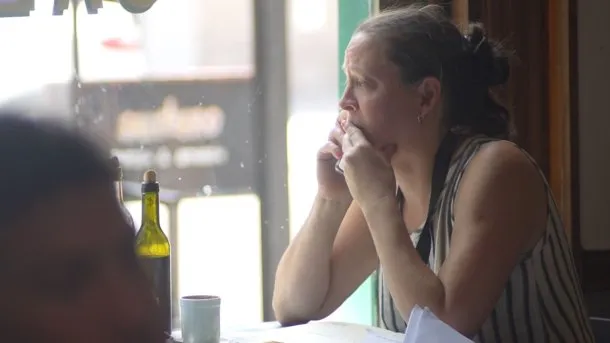 Imagen de una madre angustiada buscando un turno médico para su hijo, ilustrando el posible impacto de la reforma laboral en la cobertura de salud