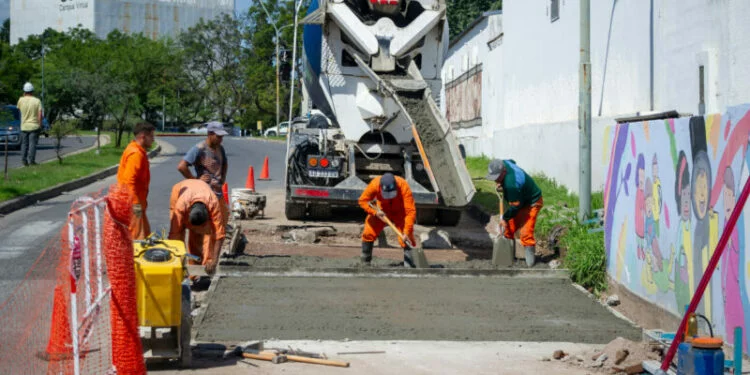 Trabajadores realizando obras de bacheo con hormigón en una intersección de Córdoba