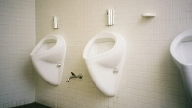 Hombre orinando sentado en un baño