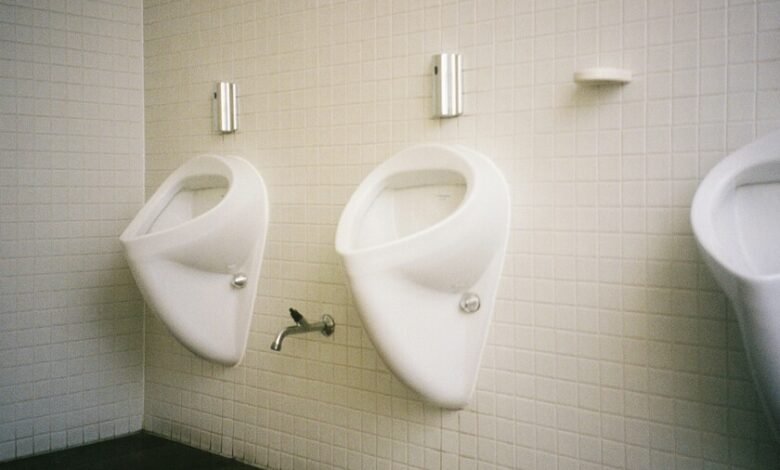 Hombre sentado en un baño orinando