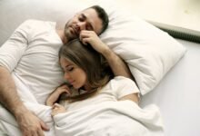 Pareja durmiendo en una cama con edredón