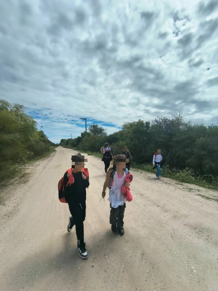 Niños y docentes caminando hacia la escuela en Villa Posse