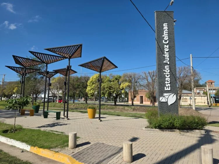 Imagen de la ciudad de Estación Juárez Celman con un fondo de montañas y un sol naciente