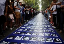 Imagen de una marcha en Plaza de Mayo con banderas y carteles en memoria de las víctimas de la dictadura