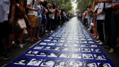 Imagen de una marcha en Plaza de Mayo con banderas y carteles en memoria de las víctimas de la dictadura