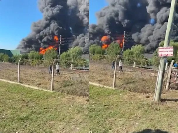 Imagen de un incendio en una fábrica con humo negro y espeso