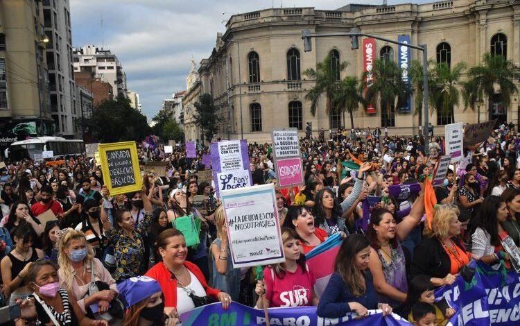 Mujeres marchando con carteles y banderas en una manifestación
