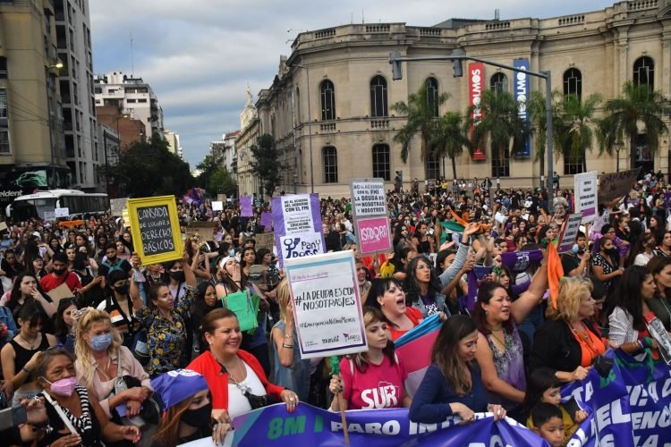 Mujeres marchando con carteles y banderas en una manifestación