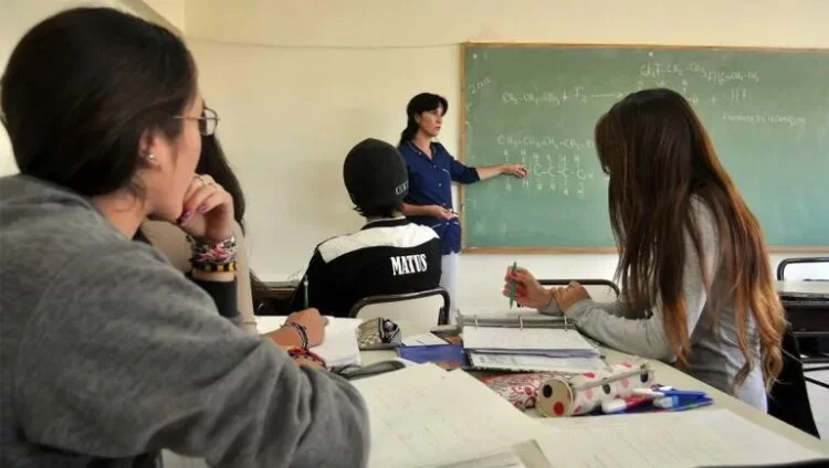 Estudiantes y docentes en una escuela cordobesa, con un fondo de seguridad y vigilancia