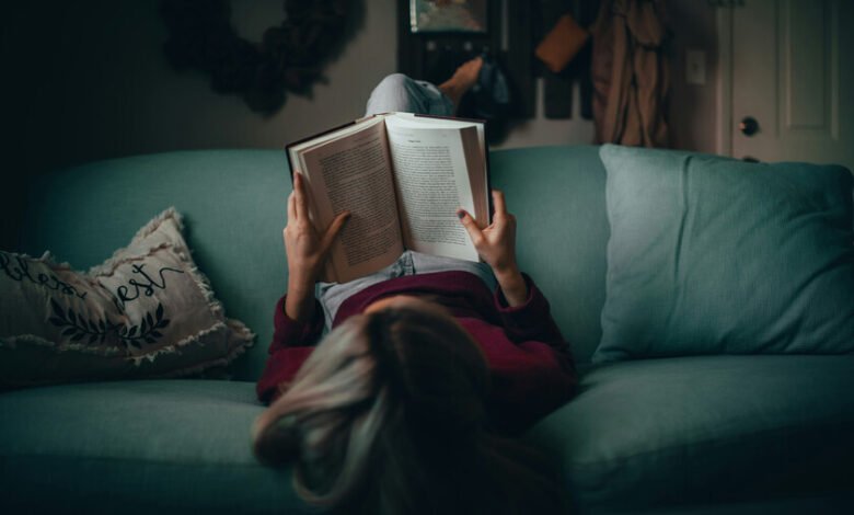 Persona leyendo un libro en una biblioteca