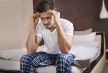 Imagen de una persona dormida con una expresión de dolor en el rostro