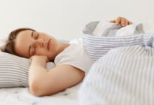 Persona durmiendo en una cama con una almohada y una manta