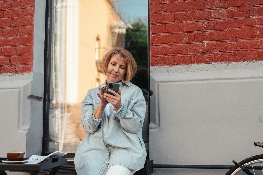 Mujer sonriente con una tableta, simbolizando el empoderamiento digital durante la menopausia