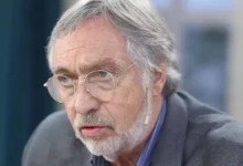 Foto de Luis Brandoni en escena, sonriendo y saludando al público