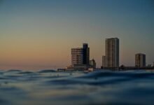 Una imagen de una costa tranquila con personas disfrutando del sol y el mar