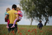 Padre y madre jugando con sus hijos en el parque