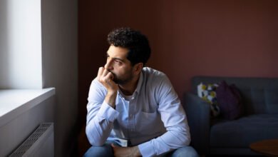 Una persona con una expresión de ansiedad, rodeada de peligros y obstáculos