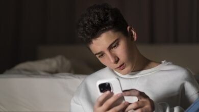 Imagen de un joven con una expresión de preocupación mientras usa su teléfono móvil