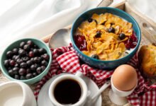 Persona desayunando en una mesa con frutas y cereales