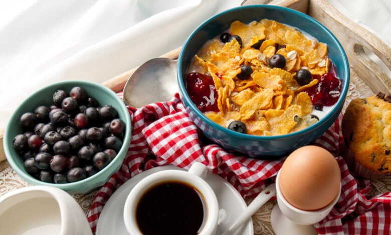 Persona desayunando en una mesa con frutas y cereales