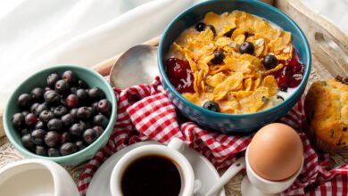 Persona desayunando con una taza de café y un bol de frutas