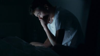 Persona despierta a las 2 de la madrugada, sentada en la cama con una expresión de confusión