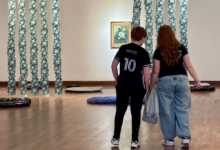 Imagen de una persona visitando un museo con una obra de arte de fondo