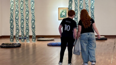 Imagen de una persona visitando un museo con una obra de arte de fondo