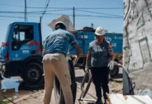 Imagen de un camión de descacharreo en la calle, con personas alrededor