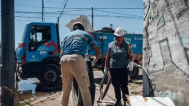 Imagen de un camión de descacharreo en la calle, con personas alrededor