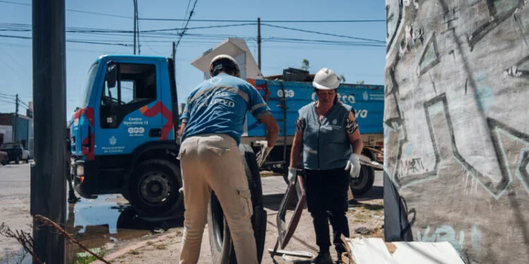 Imagen de un camión de descacharreo en la calle, con personas alrededor