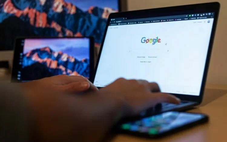 Persona trabajando en una laptop con una pantalla que muestra el logo de Google