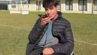 Grupo de jóvenes sonrientes con alfajores en la mano, apoyando a su compañero Juan Martín