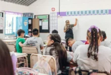Imagen de un salón de clases con estudiantes y un docente