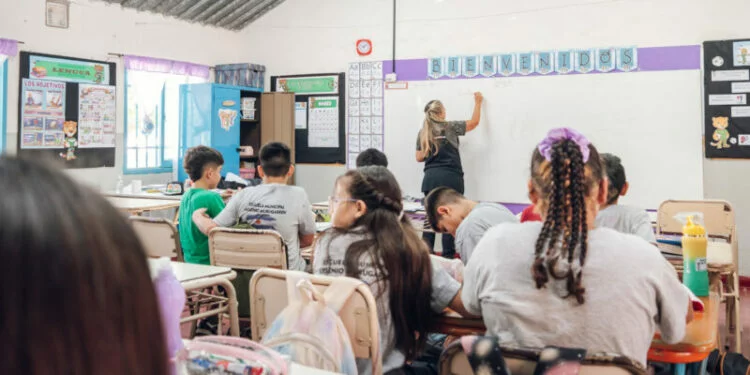Imagen de un salón de clases con estudiantes y un docente